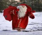 Санта Клаус проведение большой мешок с подарками Рождество в лесу